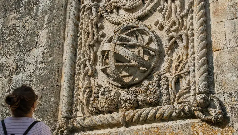 Carved limestone rope mouldings and a stone armillary sphere on a wall