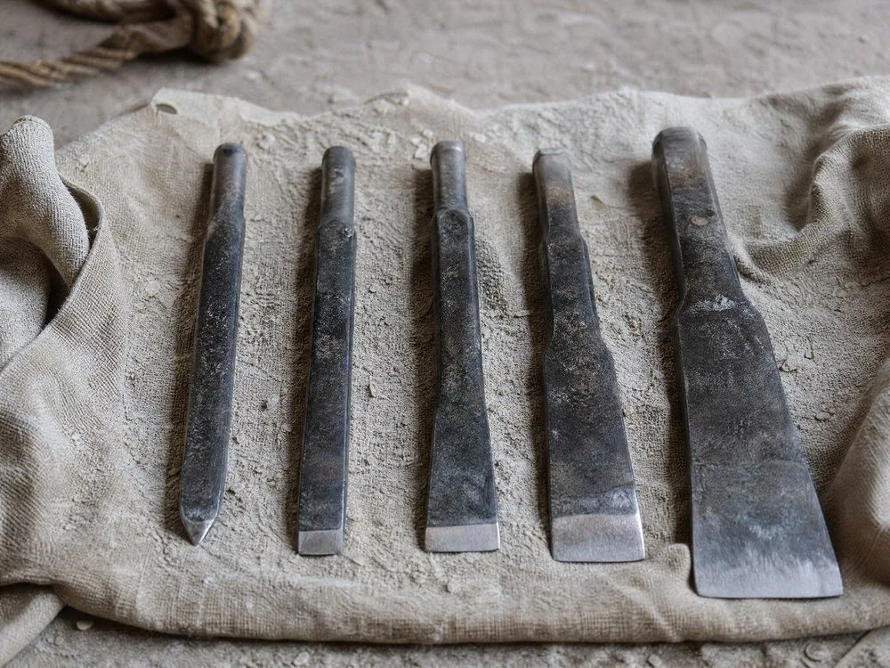 Stone chisels laid out on canvas