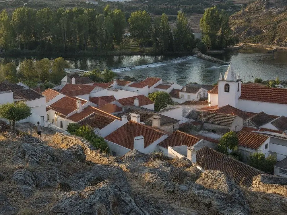 Terracotta rooftops of a small Portuguese town beside a river